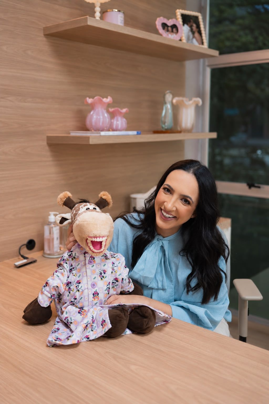 Dra. Dayane com fantoche de girafa usado no atendimento lúdico